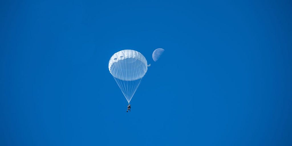 Parachute floating calmly with moon in the back
