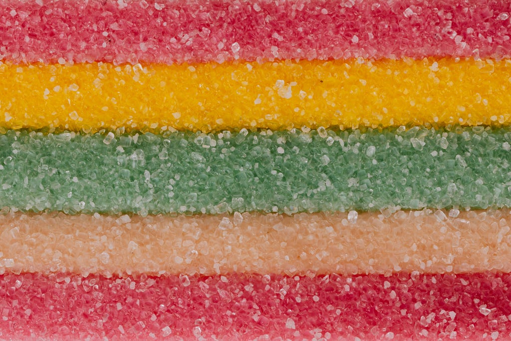 Multicolored background of yummy sprinkled sweets placed in vertical lines