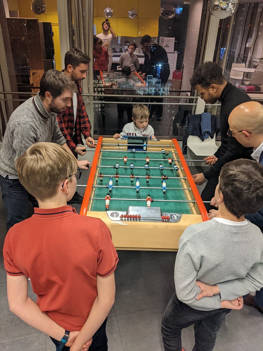 Picture of employees and trainees playing Foosball in a company breakroom