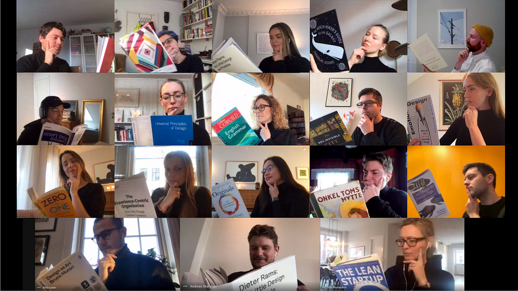 A video still of a Designers Day team meeting, with 16 designers in individual video squares in black turtlenecks, books, and pensive looks.