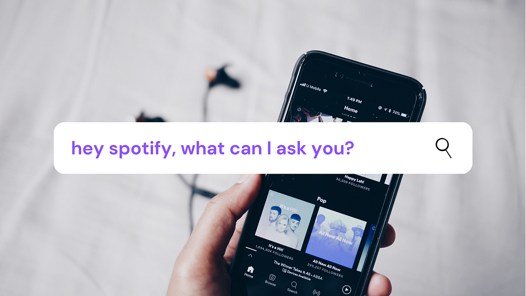 image of a close-up of someone’s hand gripping an android phone with the spotify homepage open. overlayed on top of the image is a line of text that reads, “Hey Spotify, what can I ask you?”