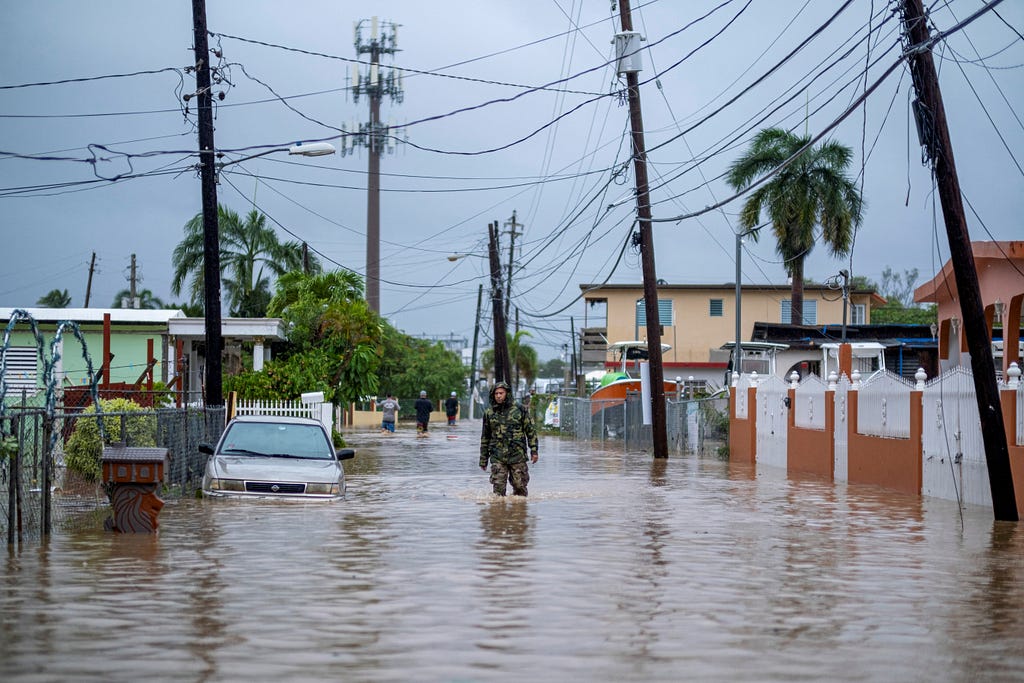 A member of the Puerto Rico National Guard wades through water in search for people to be rescued after Hurricane Fiona in Salinas, Puerto Rico, September 19, 2022. Photo by Ricardo Arduengo/Reuters