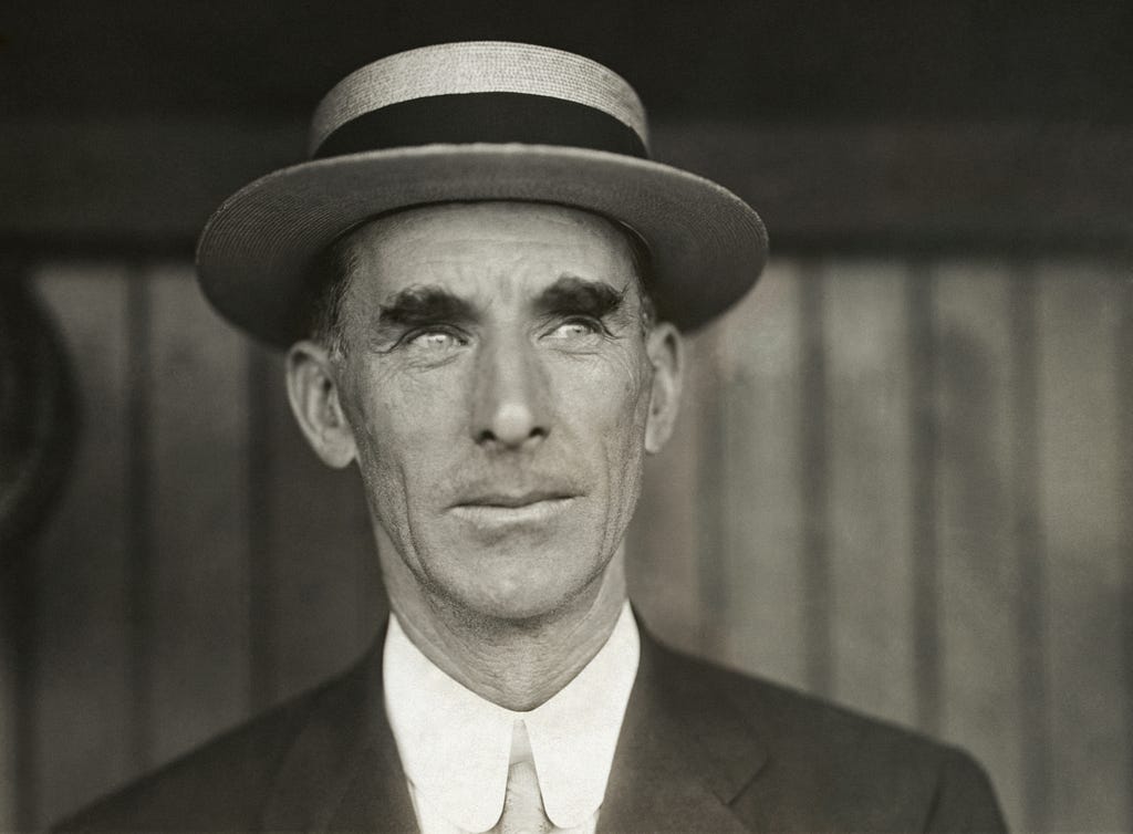 A middle-aged man from 1911, shot from the shoulders up. The man, Connie Mack, who is the manager for the Philadelphia Athletics, is wearing a jacket and tie and a hat. He stares off to his left toward something we can’t see, but can only imagine, thanks to his dreamy look.