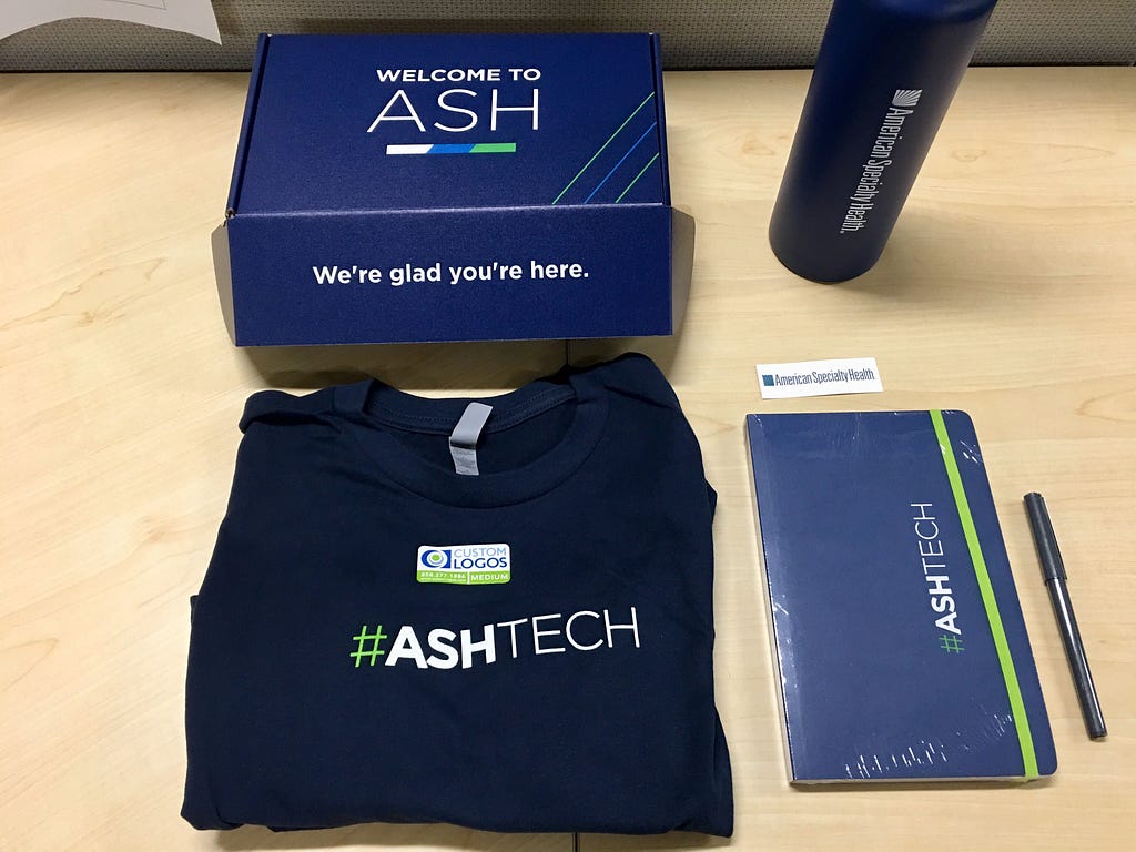 Image of a box, shirt, water bottle, and notebook