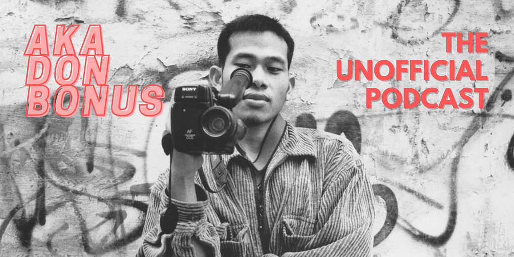 A black and white image featuring Sokly Ny (AKA Don Bonus) pointing a camcorder back to the camera and looking through the viewfinder. On the top left of the image there is text that reads “AKA DON BONUS” in pink, and on the right of the image is text that reads “THE UNOFFICIAL PODCAST” in red.