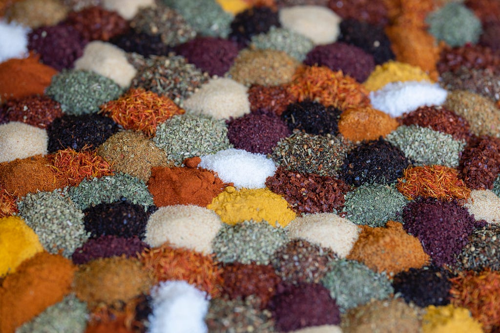 An array of different powdered and colourful spices in small piles.