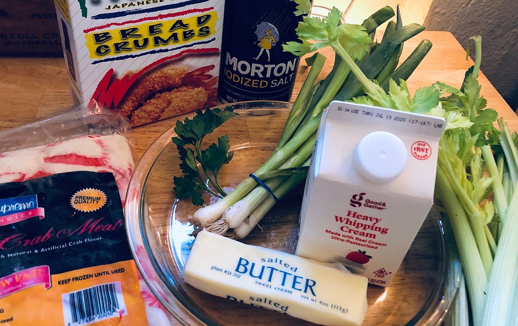 Ingredients for devilled crab: butter, heavy cream, green onions, celery, imitation crab, fresh parsley, and bread crumbs.