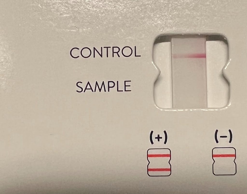 The test card from an at-home covid test. The card indicates a negative result.