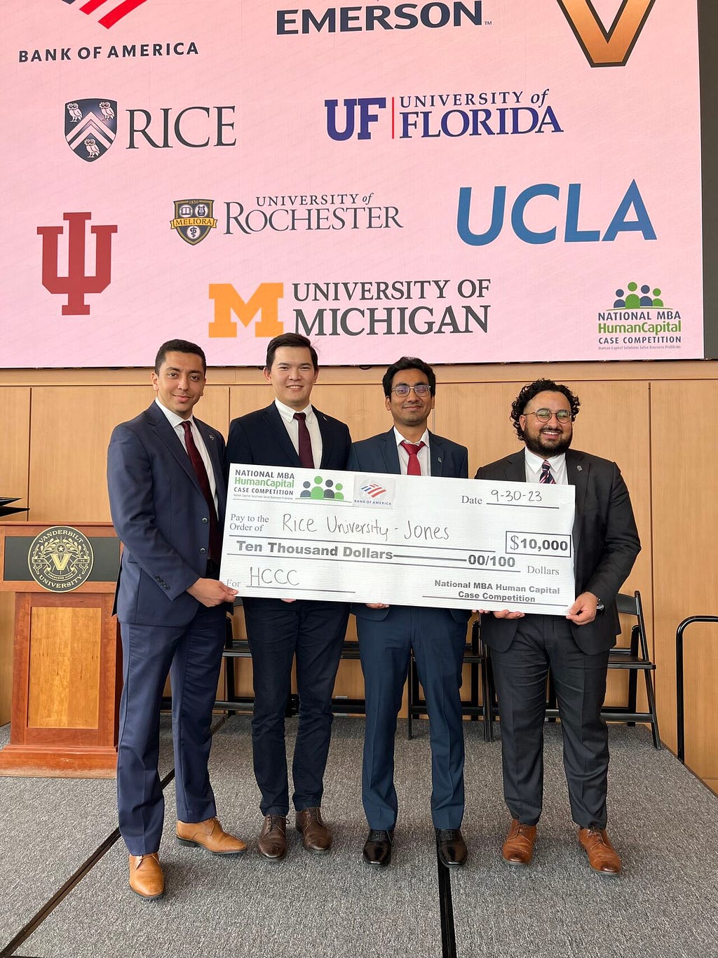 Chakib and colleagues holding a large check for $10,000.