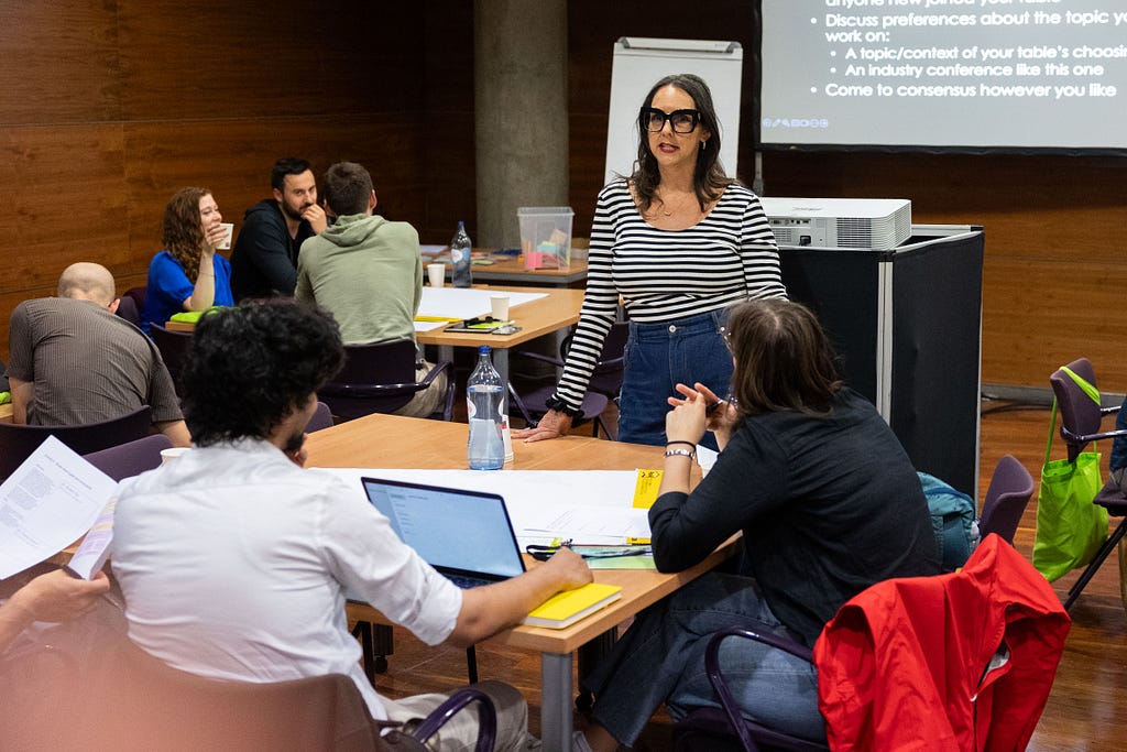 Meghan speaking to a group of attendees at a table.