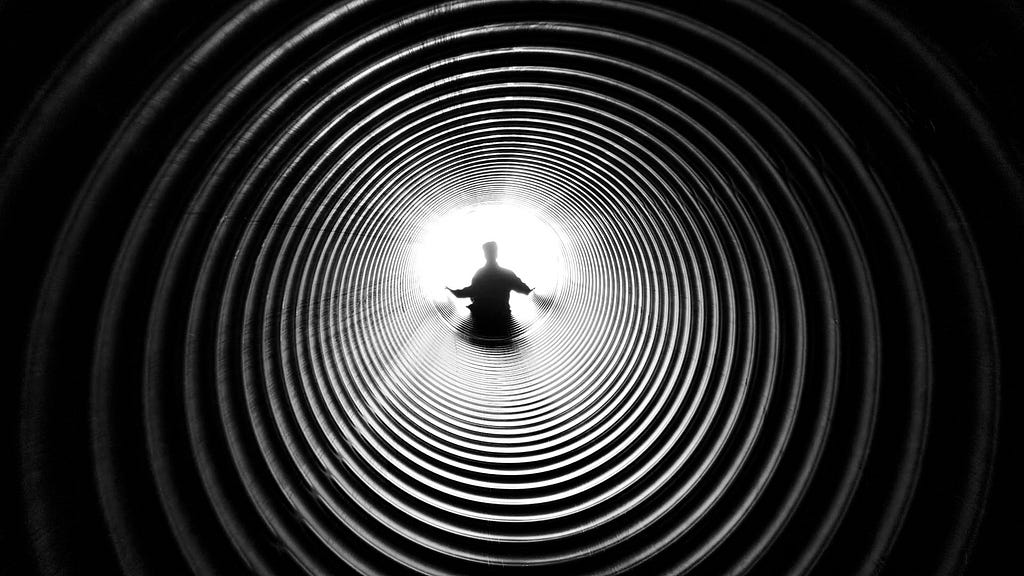 A man looking down a deep tunnel, courtesy Anthony Derosa, Pexels (211816)