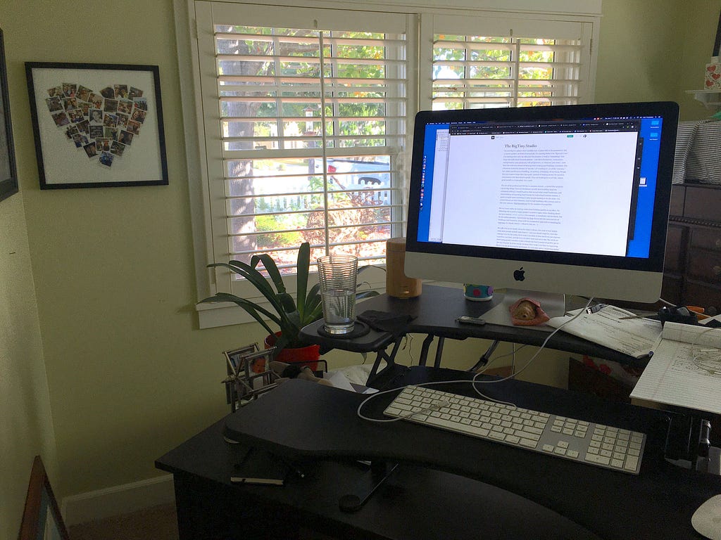 Home of the Big Tiny Studio — a home office with computer and view of outside