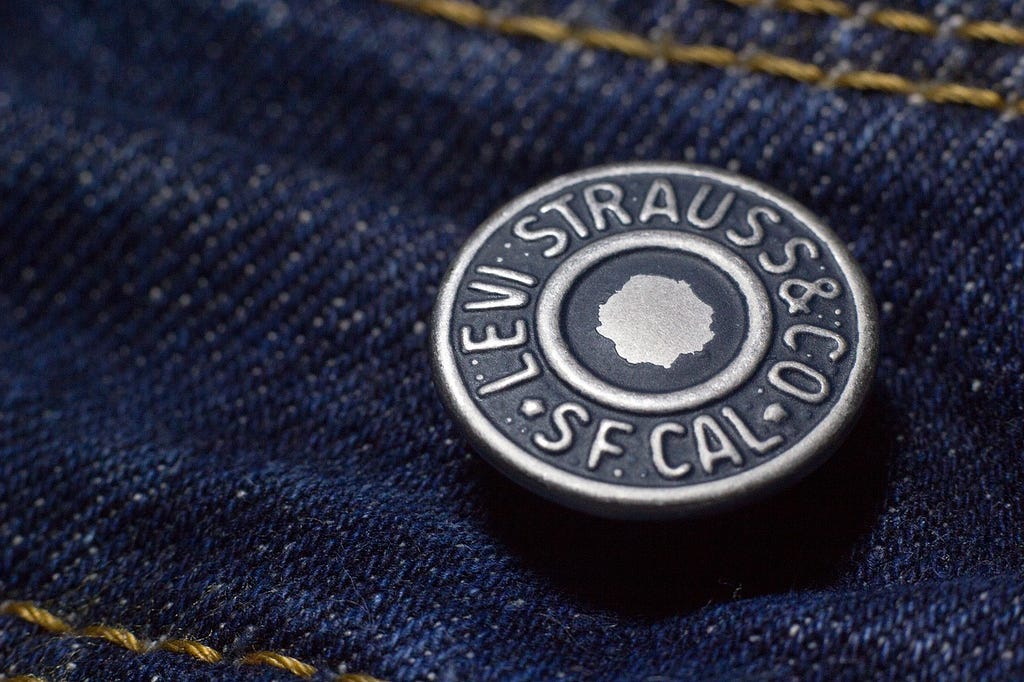 A Levi’s Jeans button on dark blue denim.