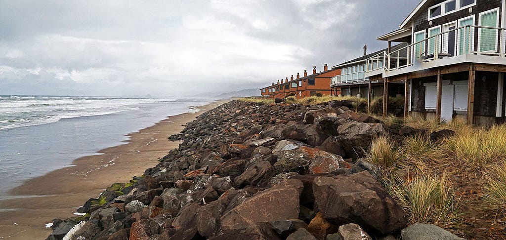 Oceanfront homes with boulders piled along the front to protect them from erosion.