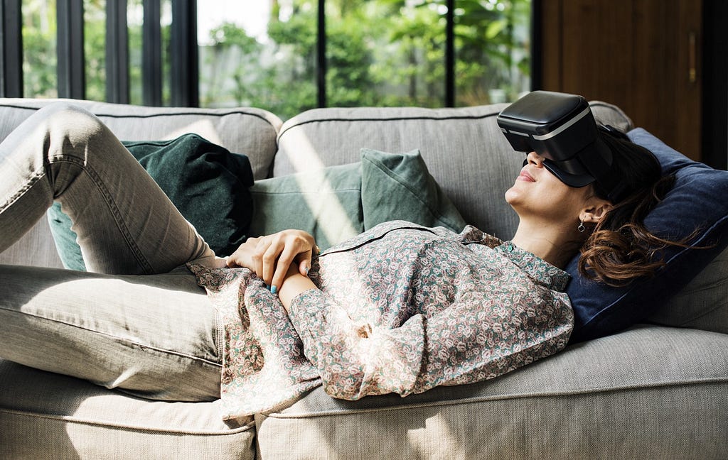 Lady sitting on the couch and exploring the world using VR