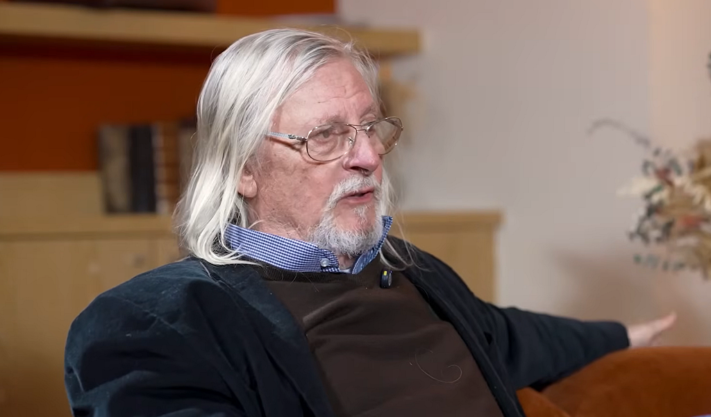 Didier Raoult, cheveux blancs et lunettes, assis lors d’une interview vidéo consacrée au risque d’une nouvelle crise sanitaire.
