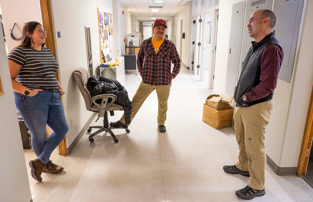 Paske and Thomas chat with Stephan Chase in a hallway of the UM Chemistry Building.