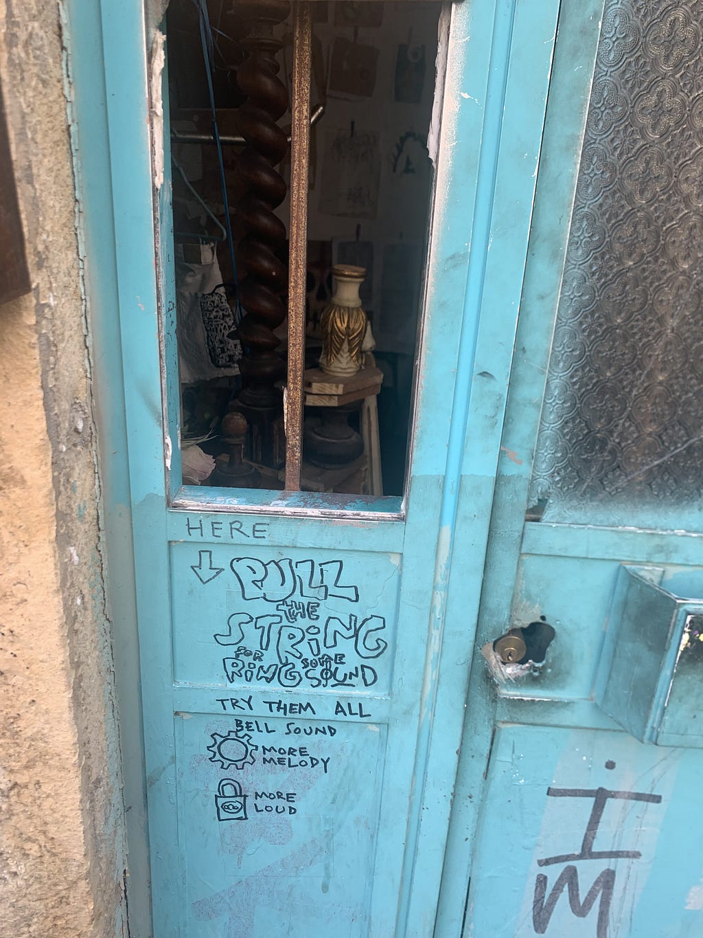 An old light blue door with a broken window.