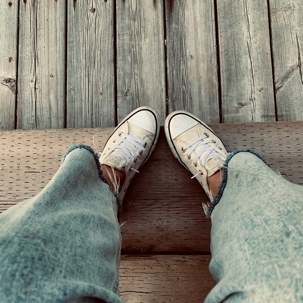 white converse shoes and blue jeans