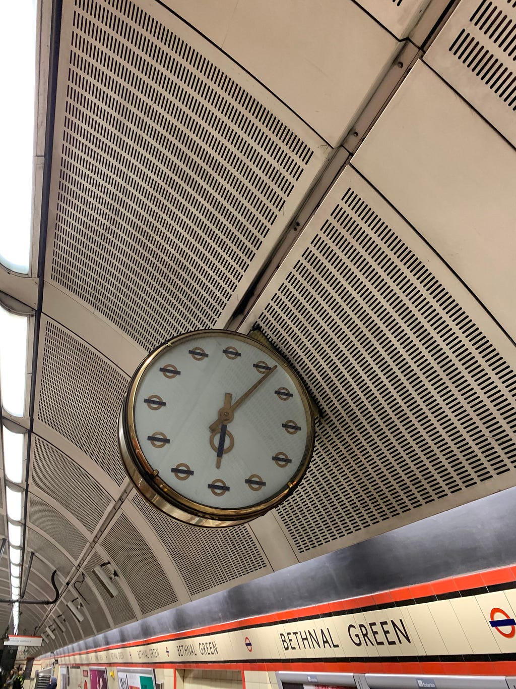 A clock on the underground. Each hour marker is a small London Underground logo.