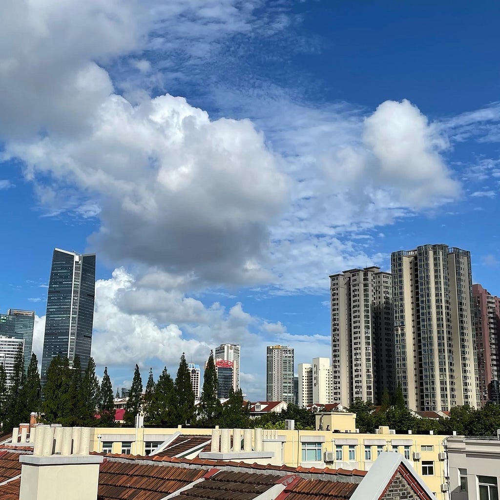 blue sky with some clouds, urban city view with tall office & residential buildings.