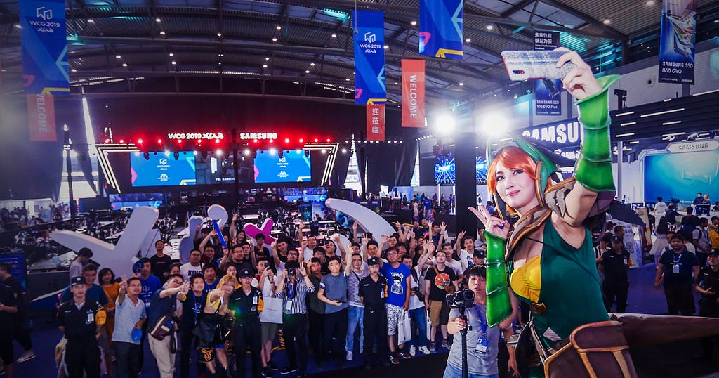 a cosplay model on the stage takes pictures with attendees for game conventions