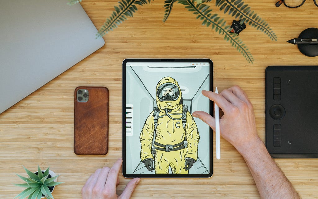 an artist’s workplace displaying an astronaut graphic design on a tablet