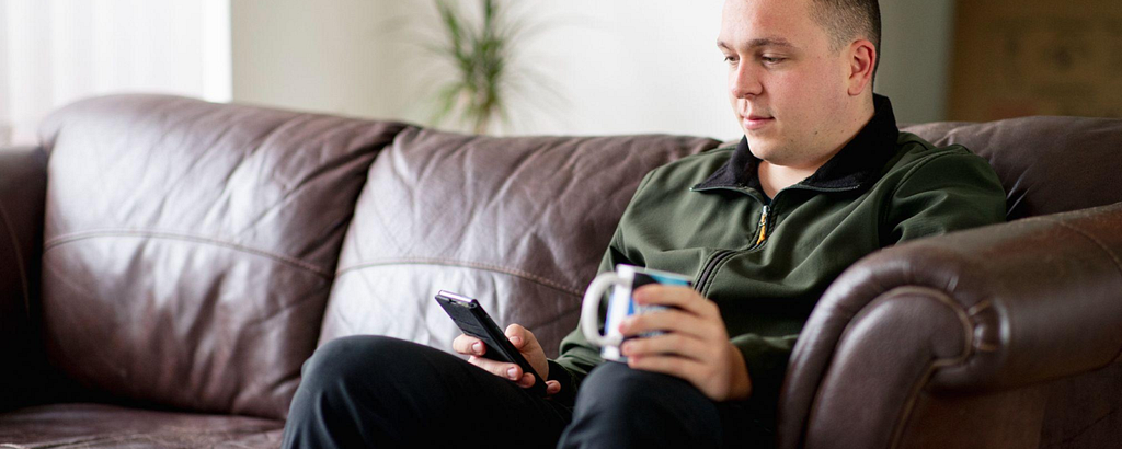 Man sitting on sofa looking at phone