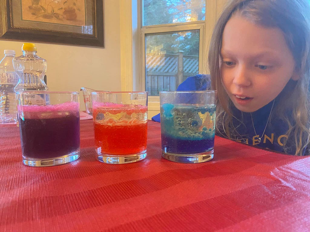 Solayah, one of my Science Rockstar Kids, investigating a beautiful set of colorful chemical reactions she created