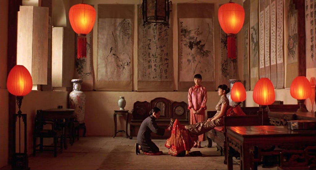 Sala com algumas lanternas vermelhas e três mulheres ao centro da imagem.