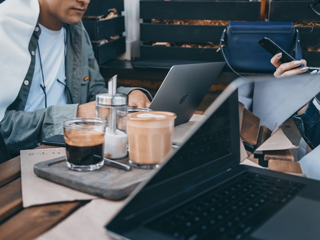 Persons work in a coffee shop with a espresso and a flat white