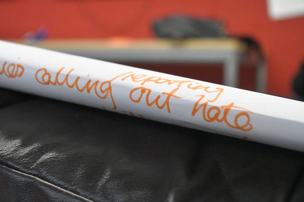 A photo of a roll of paper with the words “Calling out/reporting hate”
