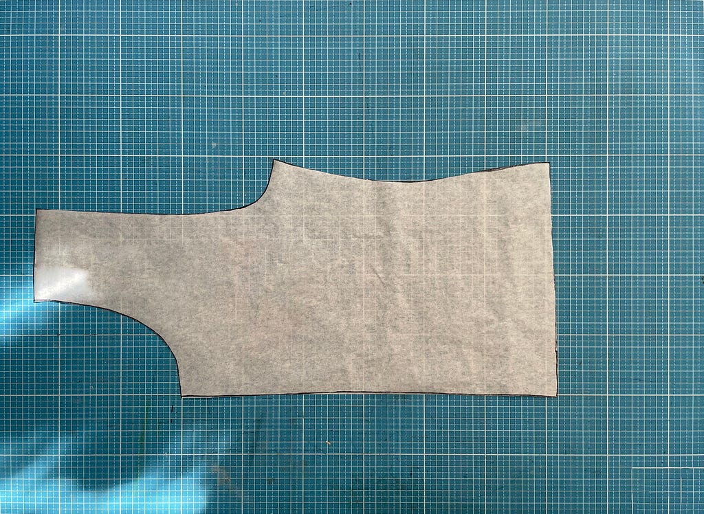 The sewing pattern lay over the cutting mat.