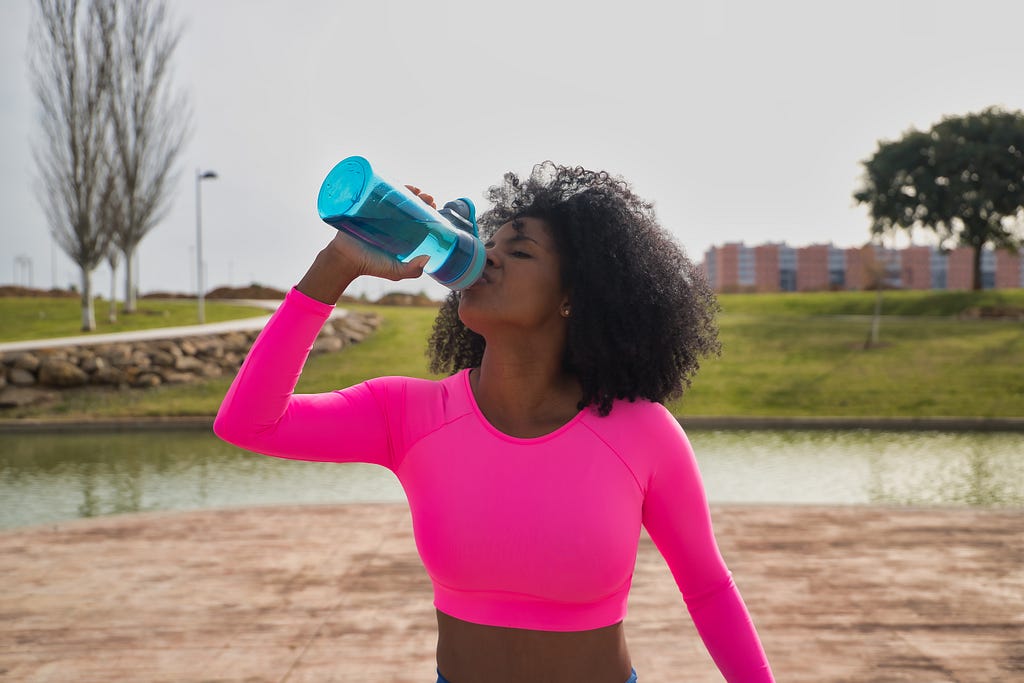 black woman drinking water for clearer skin