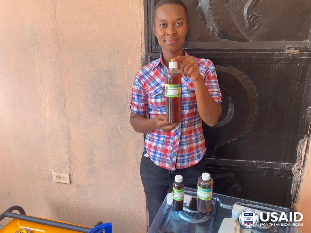 A young woman displays a bottle of castor oil.