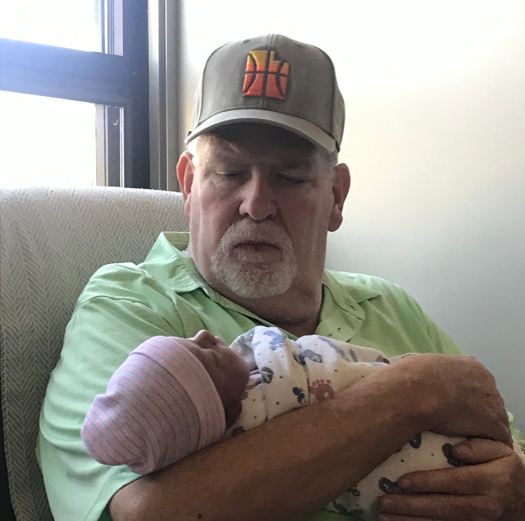 Dawning his beloved “city edition” Utah Jazz hat, Jeff Reynolds holds his newborn grandson in August of 2019.