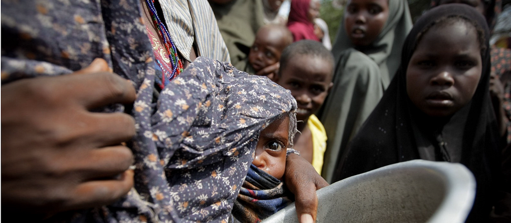 A woman holds her baby while waiting for food at the Badbado camp for Internally Displaced Persons (IDPs) during the 2011 famine in Somalia.