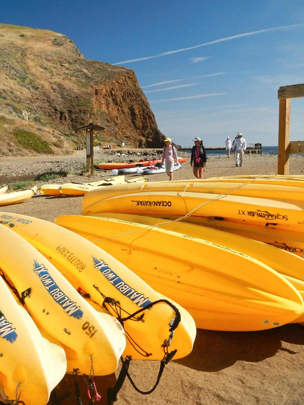 Kayaks await kayakers on guided trips in Scorpion Harbor on Santa Cruz Island in Channel Islands National Park in California. (copyright April Orcutt — all rights reserved)