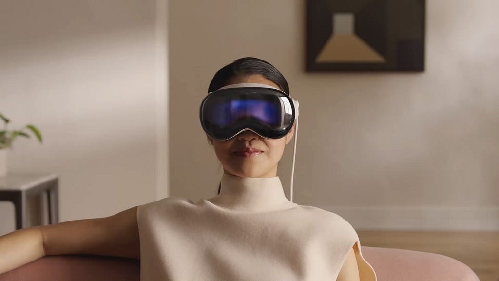 Woman sitting on a couch with a Vision Pro headset on.
