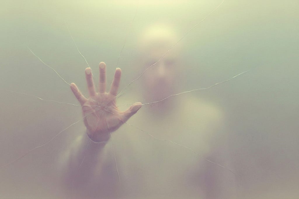 A hand against a barrier with intersecting lines or wires overlaid, representing interconnected surveillance and tracking systems.