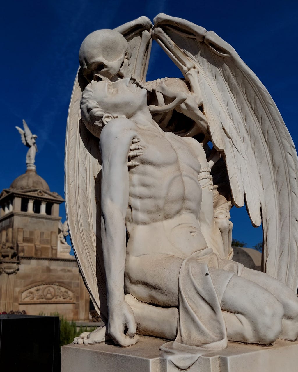 The image shows the work The Kiss of Death, where a man fell to his knees and is supported by the Death, represented by a winged skeleton, which will take him to the afterlife.