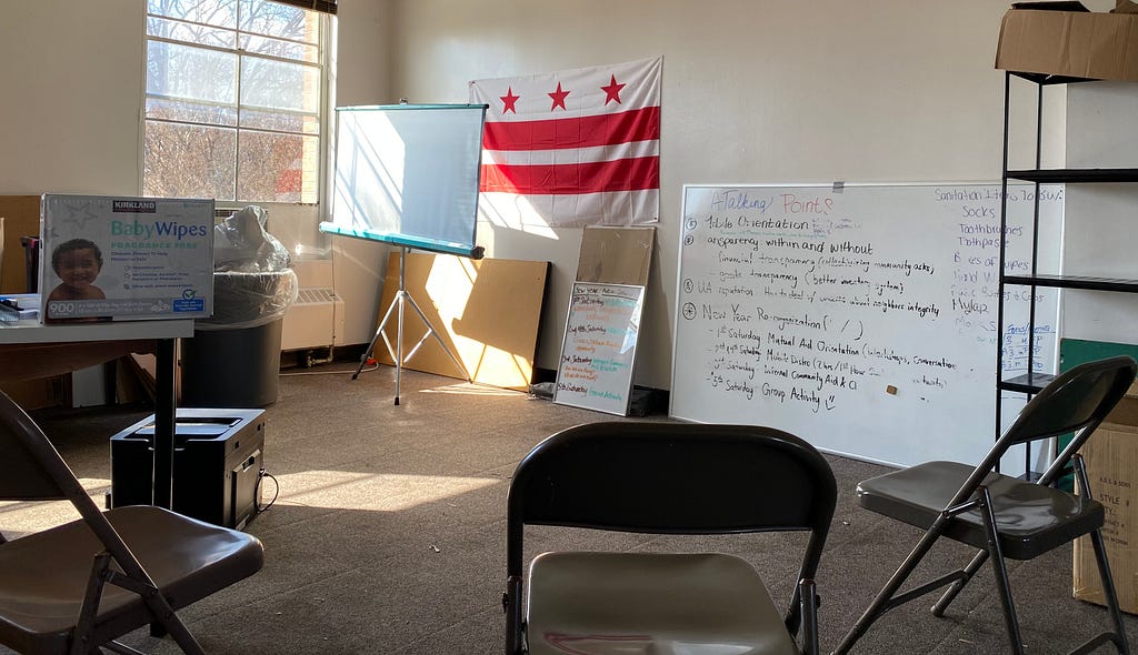 Meeting room at 16th Street Heights with folding chairs, planning whiteboard, and DC flag in the back.