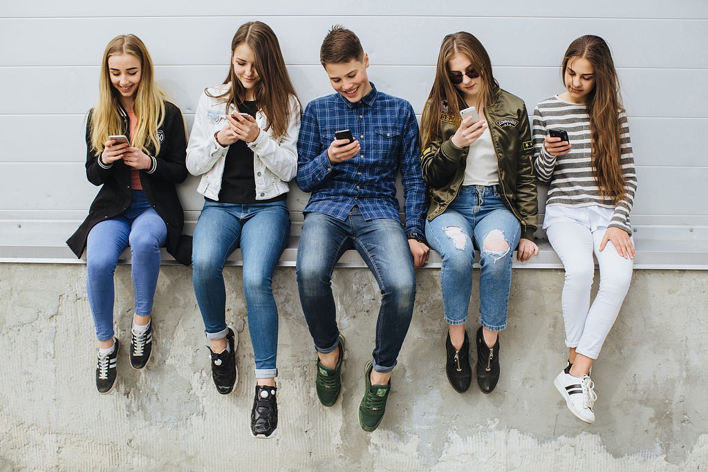 Group of teenagers outdoors with mobile phones