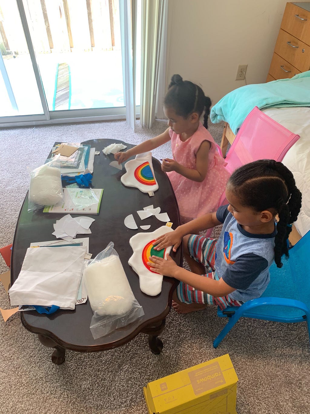 Théo, age 4, and Léa, age 3, making pillows from the activity kit.