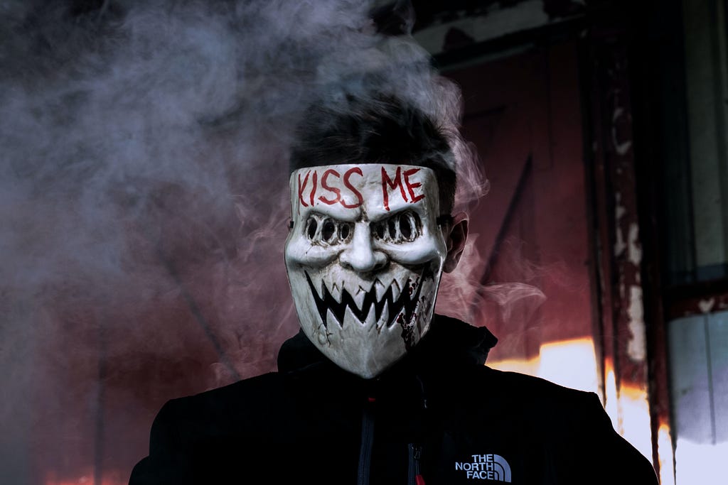 A photo of a person in a mask that says Kiss Me
