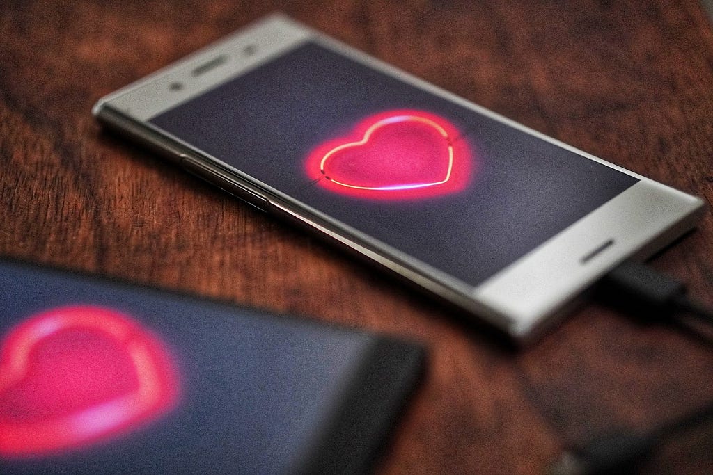 Two smartphones displaying bright red hearts.