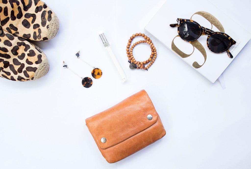 a flatlay of accessories, a bag, and shoes to represent the maximalist fashion trend on Instagram