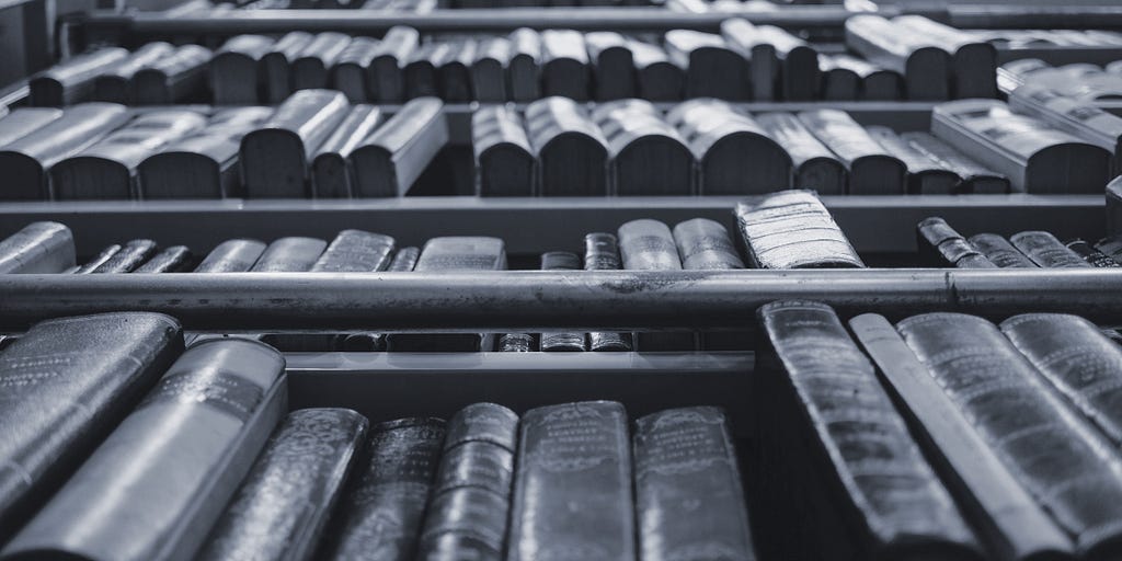 Close-up of a tall bookshelf filled with multiple large volumes.