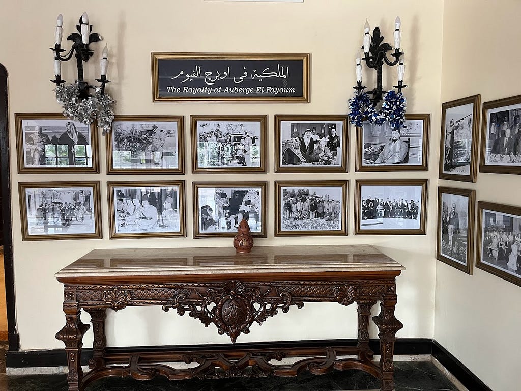 In a very classic setting, there are photo frames on the wall of the hotel entrance of king Farouk along with other royals
