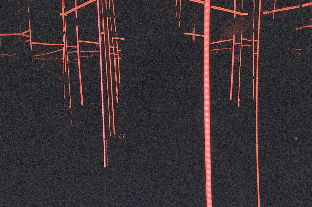 Lines of light drop vertically across a dark background.